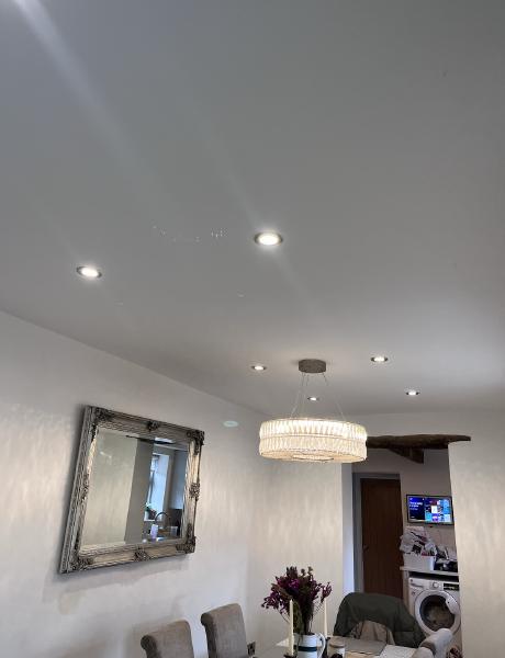 LED downlights and a crystal pendant light above a dining area